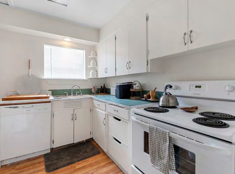 Interior view of a kitchen with white cabinets and appliances